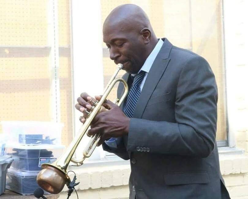 Freddie Dunn performing on trumpet in a suit